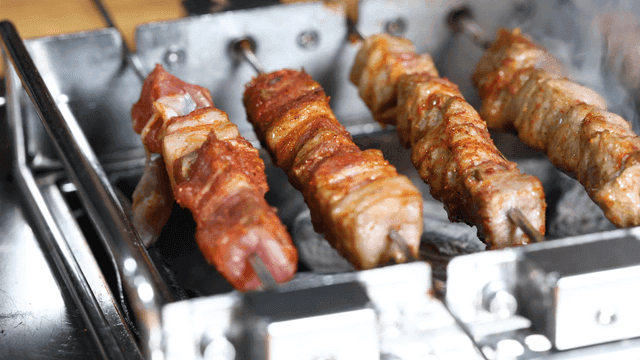Lamb skewers rotating and grilled on barbecue