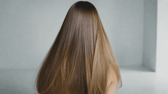 Back view of woman with long, shiny, straight hair