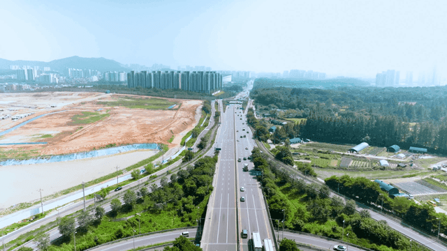 Highway surrounded by greenery and cityscape