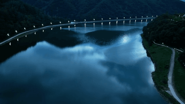 해질녘 조명이 켜진 다리와 고요한 강