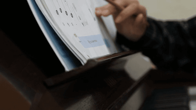 A person studying music notes indoors