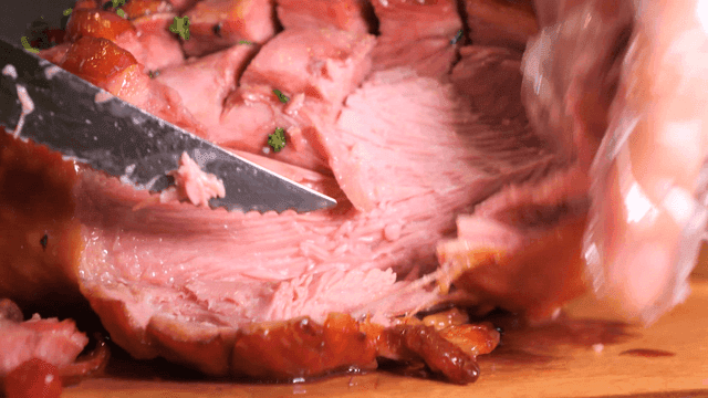 Cutting juicy roast turkey leg on cutting board