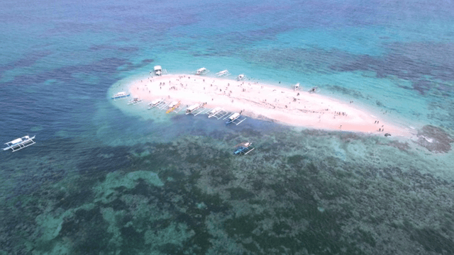 Small island with boats and tourists