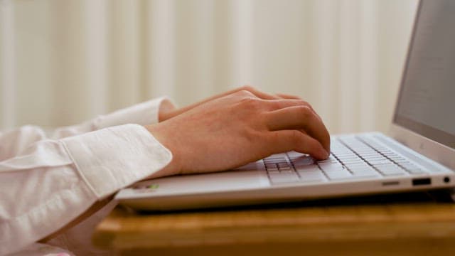 Side of Hands Typing on a Laptop