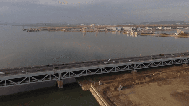 해질녘 고요한 바다 위의 긴 다리