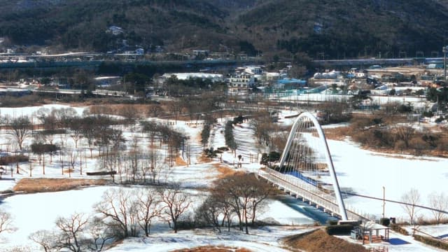 Snow-covered Park with Arched Bridge