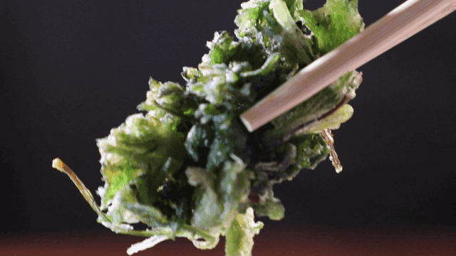 Crispy green vegetable fritter held with chopsticks