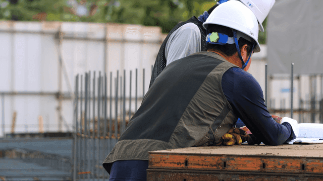 Construction workers reviewing blueprints