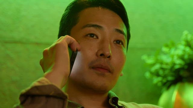 실내에서 전화 통화하는 남자