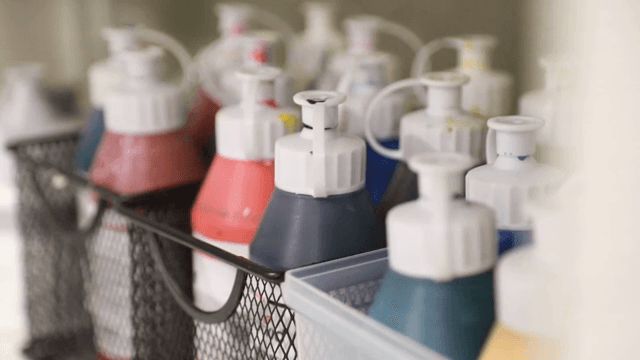 선반 위의 다양한 색상의 물감 병들