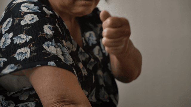 팔을 마사지하는 노인 여성