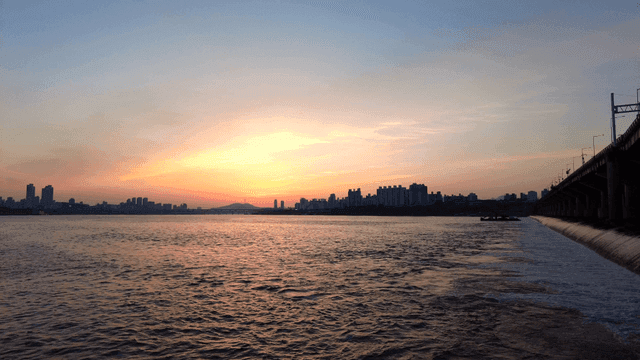 City skyline and setting sun over river