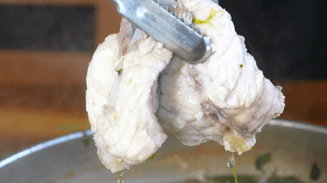 Tongs to take pufferfish clear soup out of pot along with vegetables