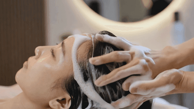 Woman washing her hair comfortably at salon