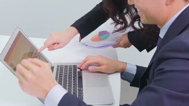 Two Professionals Preparing Presentation on a Laptop