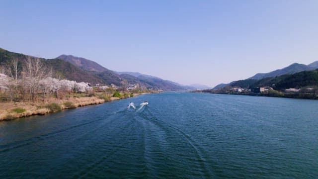 잔잔한 강의 수면을 가르며 달리는 쾌속보트와 보드