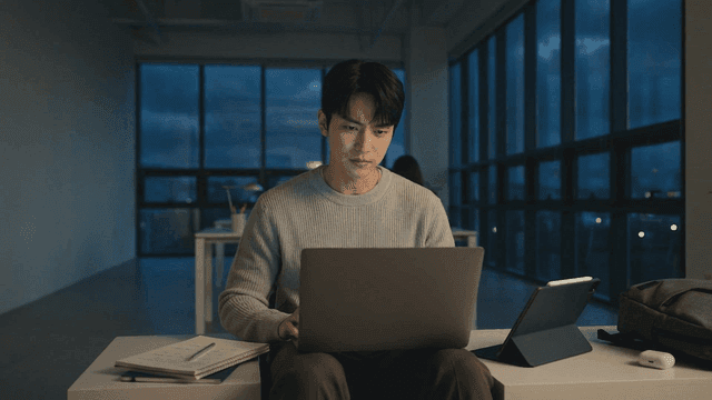 Man engrossed in his laptop late at night