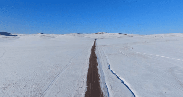 Long road through snowy plains