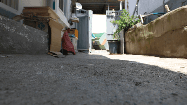 People carrying loads through a narrow alley