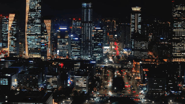 Bustling city landscape at night with high-rise buildings
