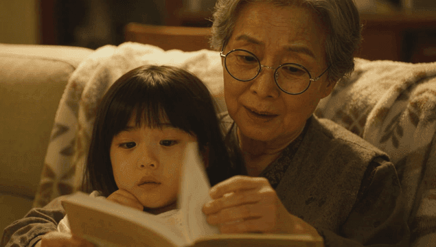 Grandmother reading a book with her granddaughter