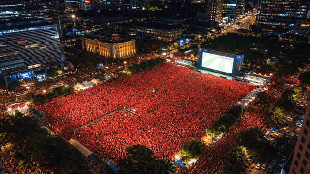 Crowd watching soccer match in city square