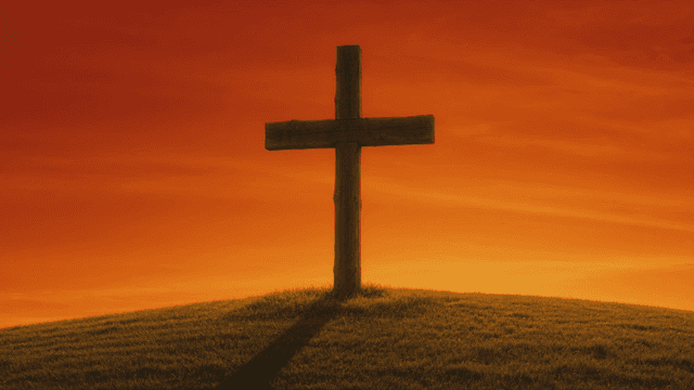 Cross on hill at sunset