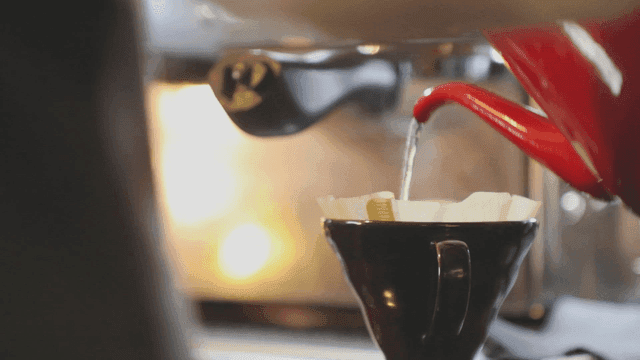 커피 필터에 뜨거운 물을 붓는 장면