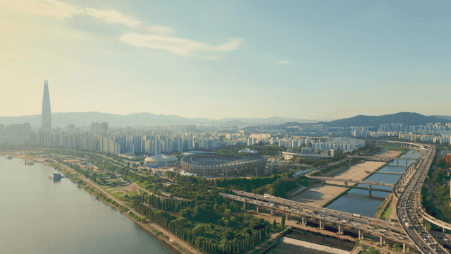 A sprawling cityscape with a river and stadium