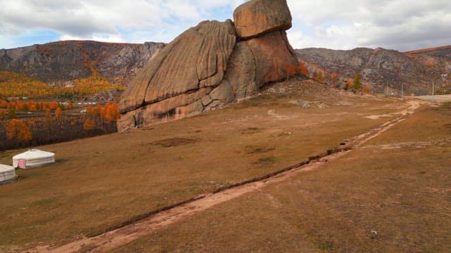 Large rock formation in a vast field landscape