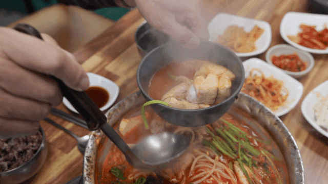 Fish stew served into bowls at table