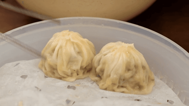 Steamed mandu being picked up with chopsticks
