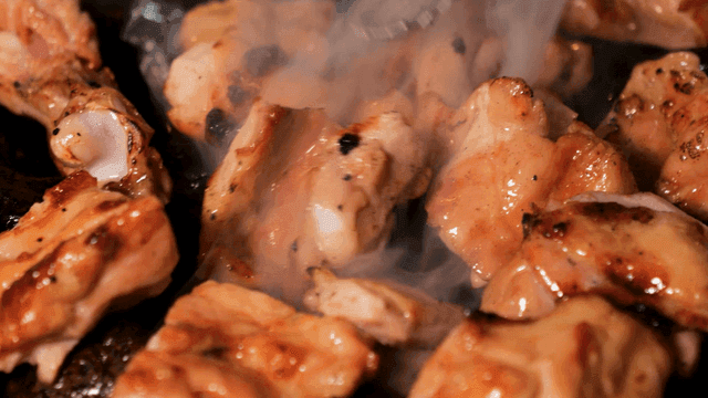 Sizzling grilled chicken galbi on hot stone charcoal grill