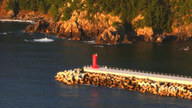Red lighthouse on a rocky coastline