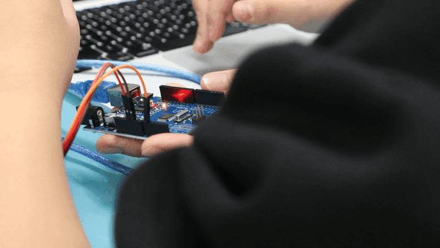 Hands working on a circuit board