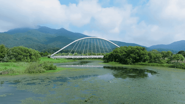 Bridge over a tranquil river with mountains