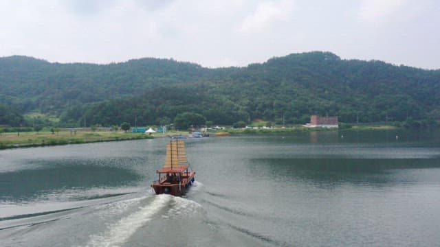 잔잔한 호수 위를 가르는 전통 돛배