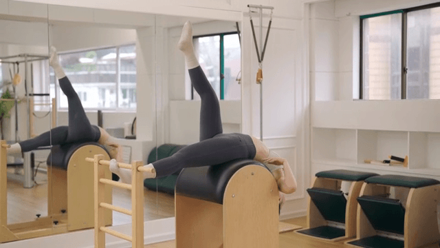 Woman exercising on a pilates barrel