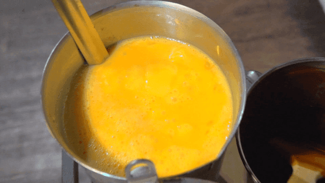 Yellow egg mixture in measuring cup in kitchen