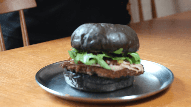 Black burger on a wooden table