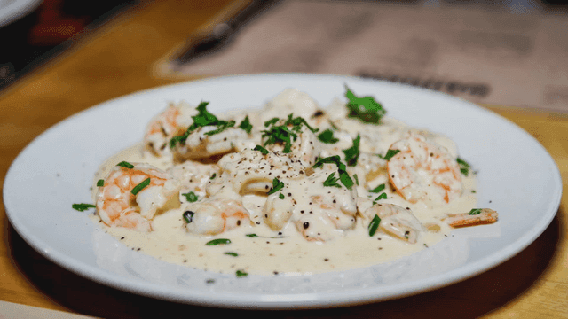 Creamy shrimp pasta garnished with herbs