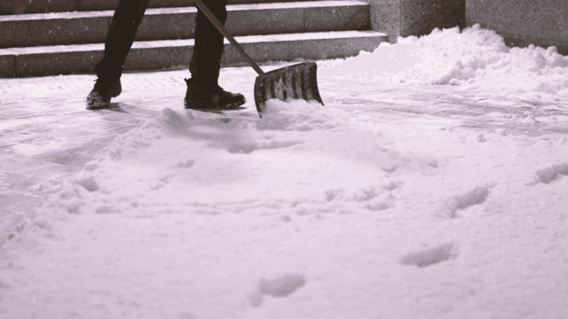 Person clearing snow from roadside