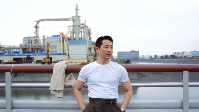 선박 옆 난간에 기대어 있는 남자