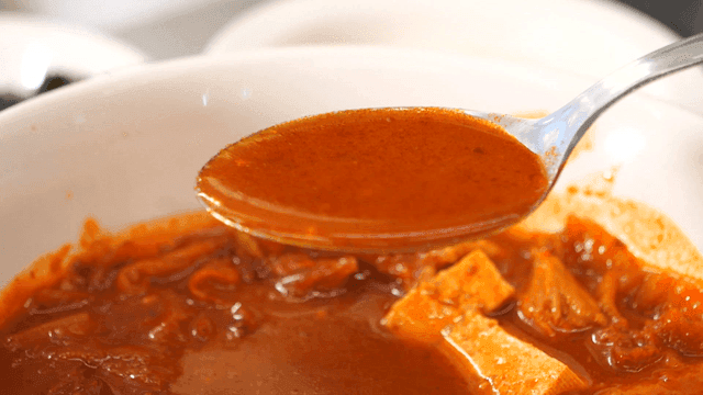 숟가락으로 퍼낸 진한 김치찌개 국물