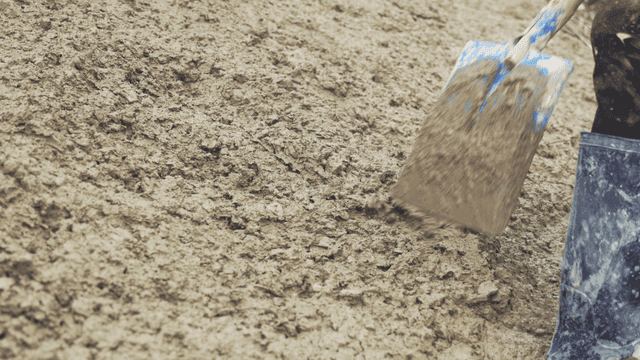 삽으로 콘크리트를 섞는 사람