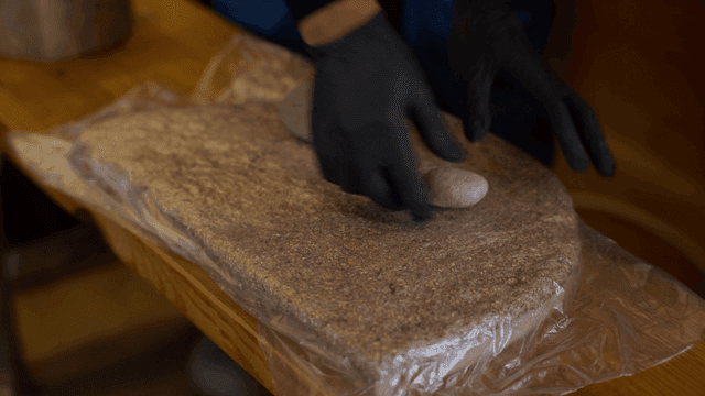 나무와 톱밥을 돌로 눌러 모양을 잡는 목공예가