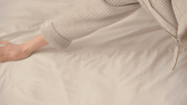 Woman making a bed indoors
