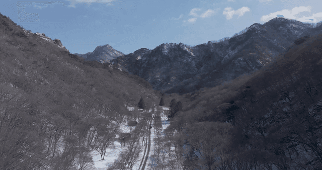 Snowy mountain road with distant peaks
