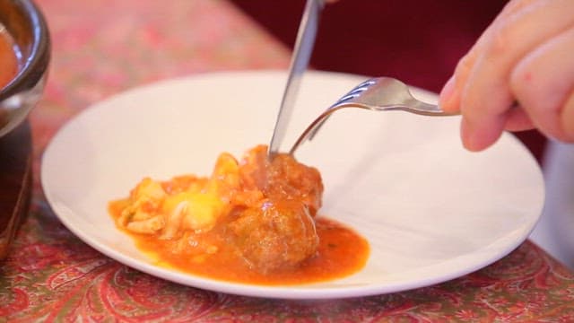 따뜻한 소스가 있는 소고기 코프타를 칼로 써는 모습