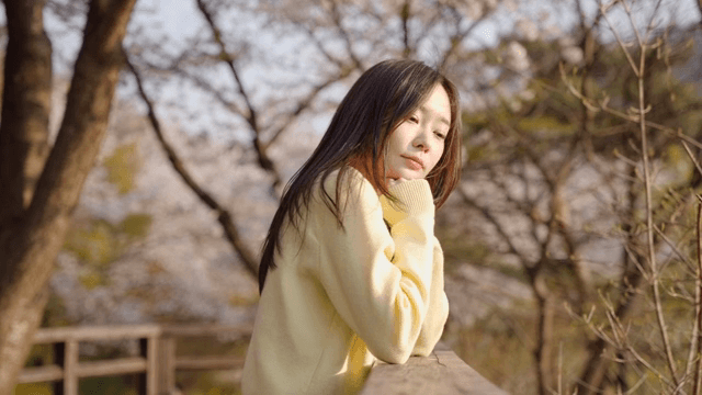 공원 난간에 기대어 휴식을 취하는 여성